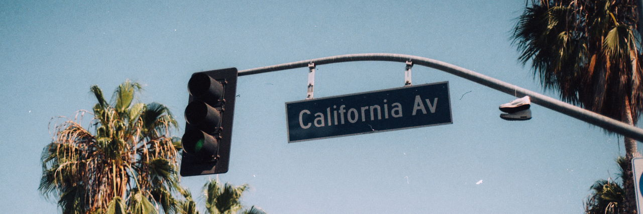 A picture of a street sign saying California Ave with palm trees in the background